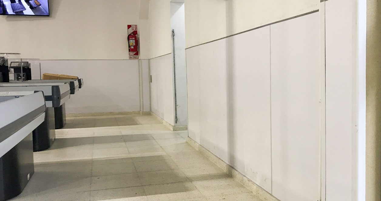 Pared revestida con placas Plastixe blancas en un pasillo del supermercado