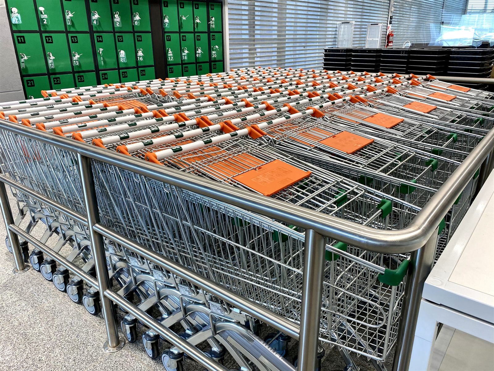 Carros de supermercado apilados con defensas de acero en una tienda